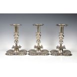 A matched set of three elaborate Edwardian silver candlesticks in the Carolean style Crichton