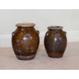 Two large graduated antique South East Asian stoneware martaban storage jars ovoid with lion mask