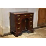 A George III mahogany kneehole desk the moulded top over a shallow full width drawer, the recessed