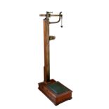 A set of Edwardian oak and brass jockey or surgery scales by W. & T. Avery Ltd. impressed maker's