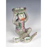 A Chinese porcelain famille rose monkey spoon stand late 20th century, the seated monkey in a