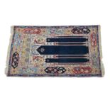 An Anatolian coupled column prayer rug early 20th century, on ivory and blue ground with rosette and
