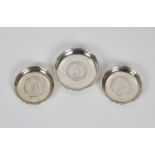 A pair of Hong Kong silver pin dishes by Wai Kee, inset with 1900 HK $1 coins, 2 7/8in. (7.5cm.)