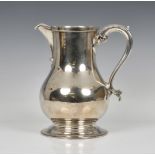 An Elizabeth II silver baluster jug Wakely & Wheeler, London, 1972, having leaf capped scroll