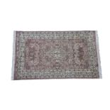 A 20th century Indian part silk rug with central medallion and vine and blossom fillers within a