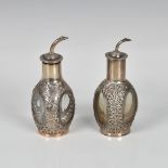 A matched pair of Oriental silver and glass scent flasks, of three sided decanter form, decorated
