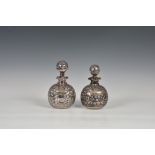 A matched pair of Edwardian Art Nouveau silver overlay glass decanters, of globular form, both