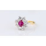 An 18ct gold, platinum, ruby and diamond cluster ring, the pinkish-red oval cut ruby, 6 x 5mm.,