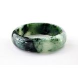 Two Chinese jade bangles, late 20th century, both in mottled dark green and celadon jade, internal