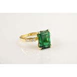 An 18ct yellow gold, green tourmaline and diamond ring, the emerald cut green tourmaline over