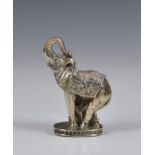An Indian silver plated elephant paperweight, elephant with trunk up, and saddle blanket, raised