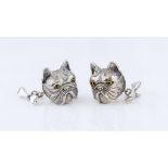 A pair of silver and emerald French bulldog and bone cufflinks