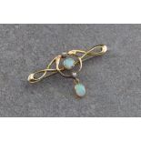 An Edwardian 15ct gold and opal bar brooch, in the Art Nouveau style, the open scrollwork brooch set