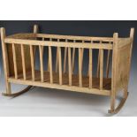 A vintage wooden dolls cradle, with stencilled flower decoration, 28¾in. (73cm.), together with