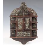 A Japanese hardwood wall hanging cabinet, probably late 19th century, the central cupboard with