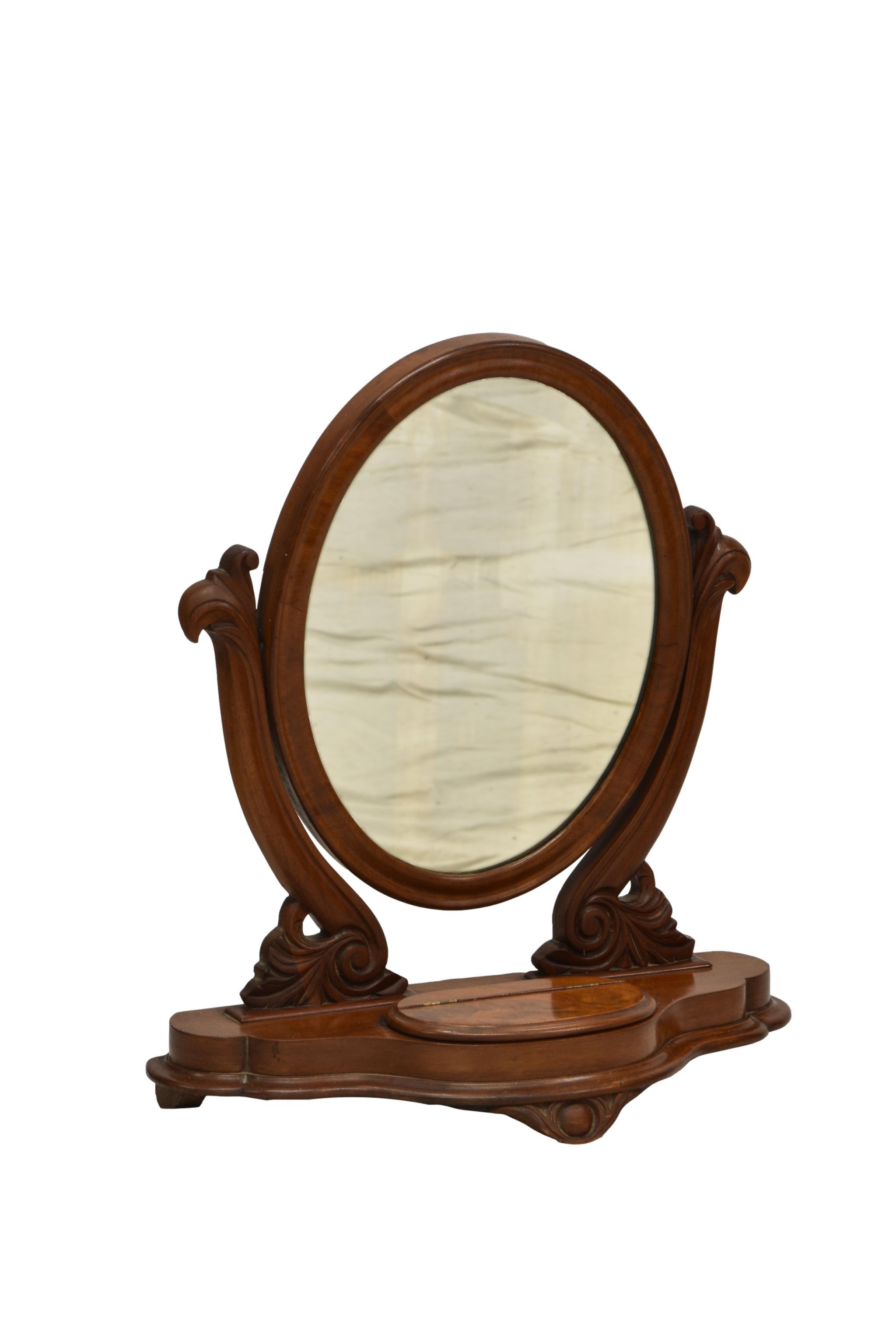 A Victorian mahogany toilet mirror, the oval mirror on scroll carved supports on a serpentine base