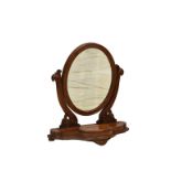 A Victorian mahogany toilet mirror, the oval mirror on scroll carved supports on a serpentine base