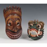 Two Chinese carved and painted wooden masks, 20th century, one of a Foo Dog, 8½in. (21.6cm.) high;
