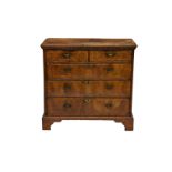 A George I walnut chest of drawers, alterations, the flared, ogee moulded cross banded top over