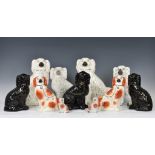 A collection of Staffordshire seated dogs, to include a white version with traditional