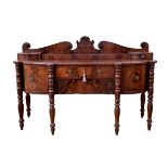 A William IV mahogany bowfront sideboard, the serpentine broken arch back with central foliate
