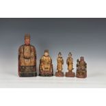 Five Chinese lacquered and parcel gilt carved wooden figures, probably 19th century, comprising