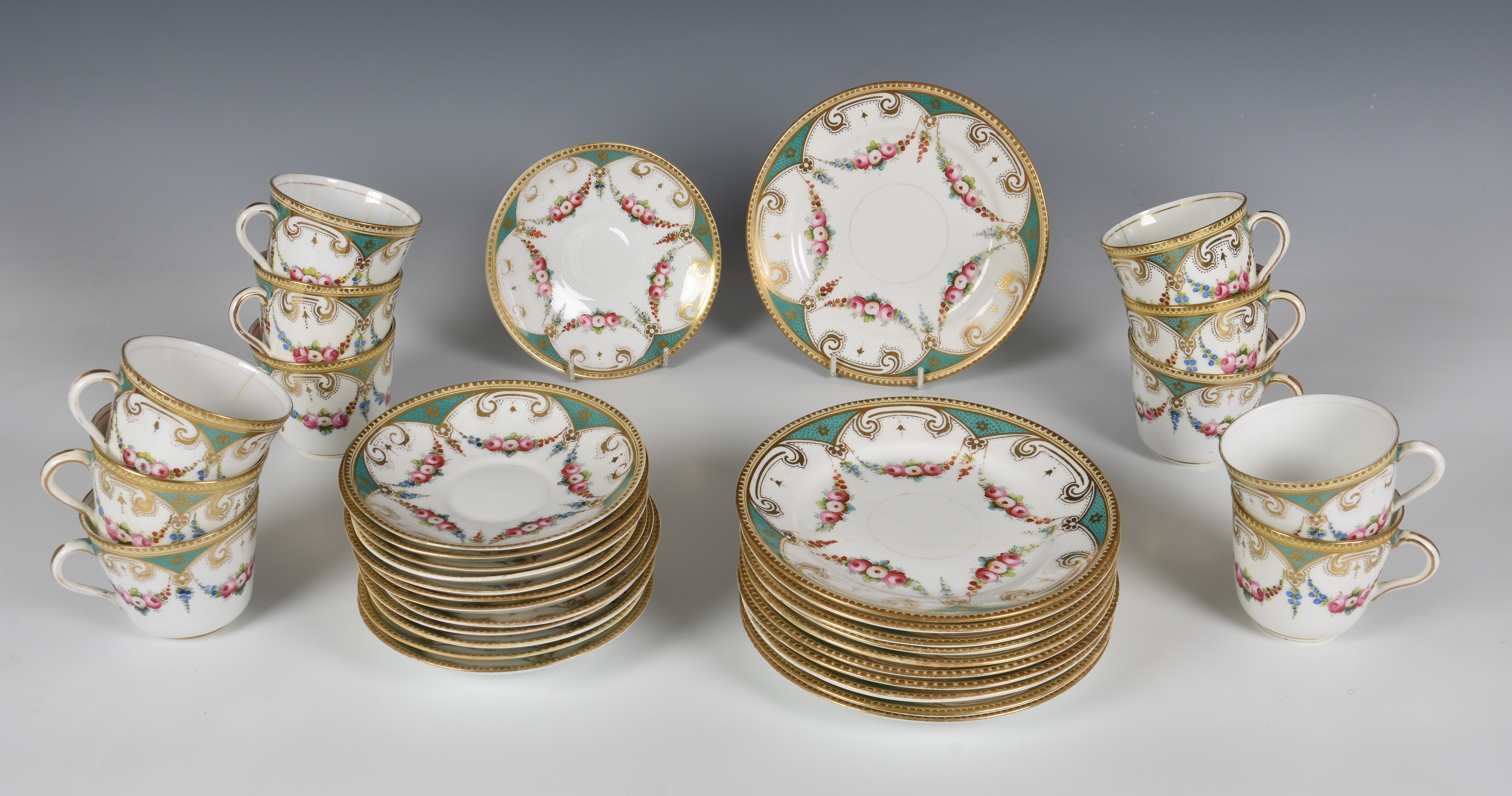 A 19th century English porcelain part tea service, decorated with floral swags on a five lobed