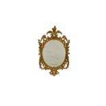 A mid-Georgian carved giltwood oval mirror, with pierced foliate cresting, the pierced scrolling