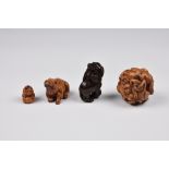 Three Japanese carved wooden netsukes, comprising a dark hardwood Buddhistic lion holding a pearl,