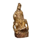 An Oriental parcel gilt stoneware figure of Buddha, 20th century, dressed in gilt robed, seated upon