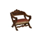 A Victorian oak X-frame chair, the crested back with carved rosette, scroll and floral decoration,