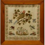 A framed Victorian needlework sampler, with a floral border and dog, bird and butterfly main panel