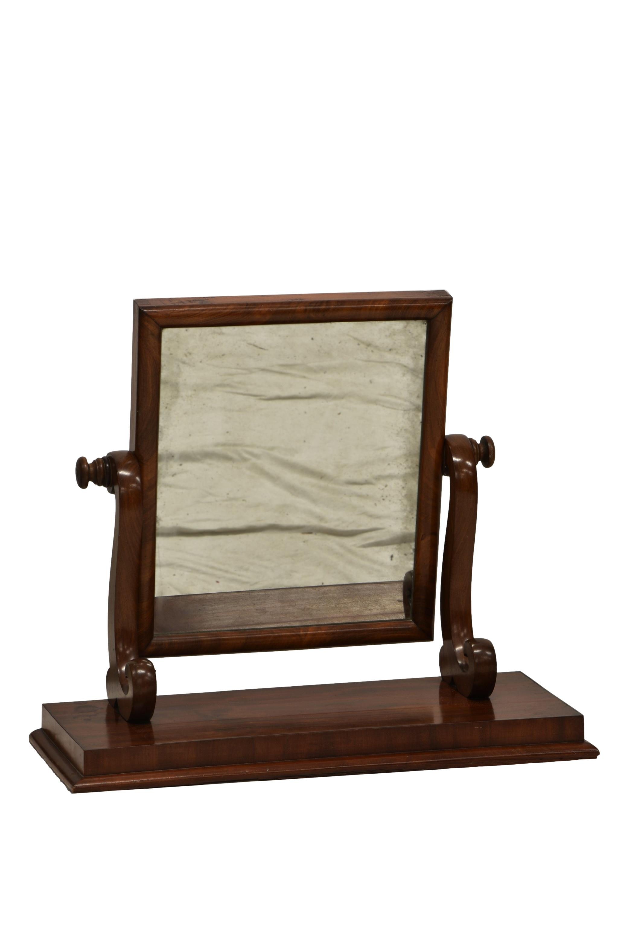 A late Victorian mahogany toilet mirror, the rectangular mirror on a plain plinth base.