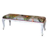 An 18th century style carved and painted window seat, the buttoned seat upholstered in a bold floral