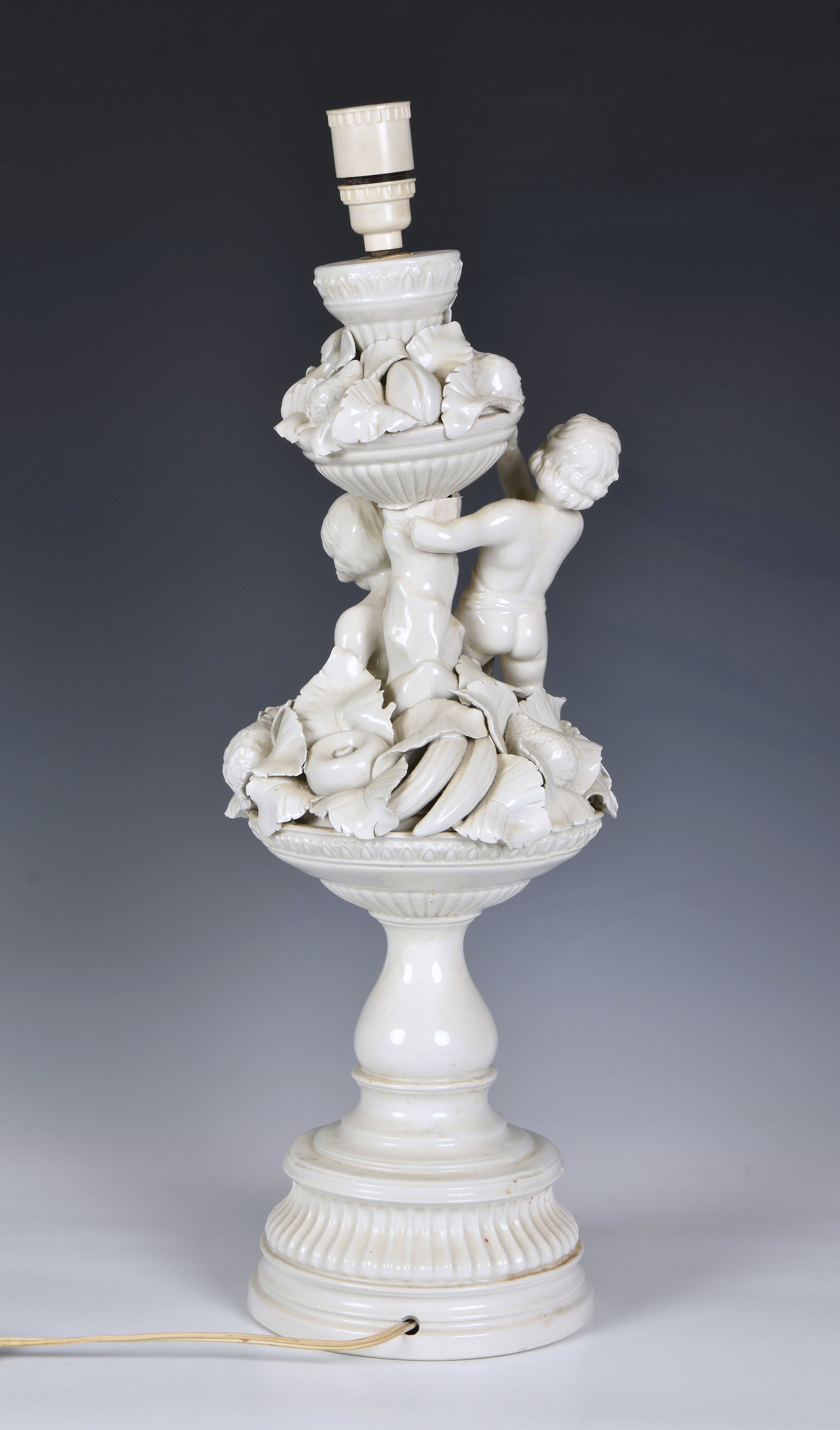 An Italian white glazed pottery table lamp, mid-20th century, modelled as two cherubs seated on an - Image 2 of 2
