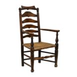 A George III stained beech and oak ladder back armchair, the shaped, scrolled top rail over a shaped