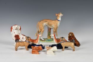 A collection of antique / vintage ceramic dog models, to include two German porcelain pug dogs,