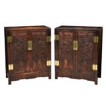 A pair of Chinese carved hardwood cabinets, the plain rectangular top over two cupboard doors with a