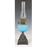 A antique oil lamp with a blue milk glass reservoir, and metal base, 22in., (55.9cm.) high.