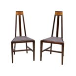 A pair of Secessionist style walnut hall chairs, early 20th century, the tapered, angular backs with