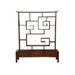 A Chinese double sided hardwood room divider, 20th century, with an asymmetrical arrangement of