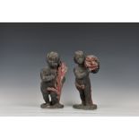 A rare pair of 18th / 19th century lead cherub figures, painted in red and black, one holding a