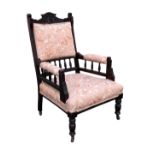 An Edwardian carved and stained walnut open armchair, the square, padded spindle back with shaped
