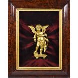 A gold gilt painted wooden cupid wall mount framed in shadow box, mounted to burgundy silk ground
