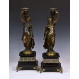 A pair of French patinated bronze candle holders, late 19th century, modeled as female Grecian water
