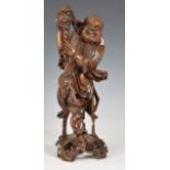 A Chinese carved wooden figure of a deity, probably early 20th century, with glass eyes and bone