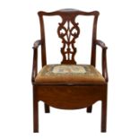 A Georgian mahogany commode chair, the yoke back with pierced splat and swept arms over a velour and