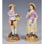 A 19th century pair of Staffordshire figures, of a young man carrying a basket of fruit and young