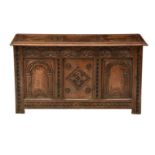 A 19th century carved oak three panel coffer, in the late 17th century style, the front with three