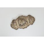 An Indian white metal pierced belt buckle, the central section decorated with a central deity on